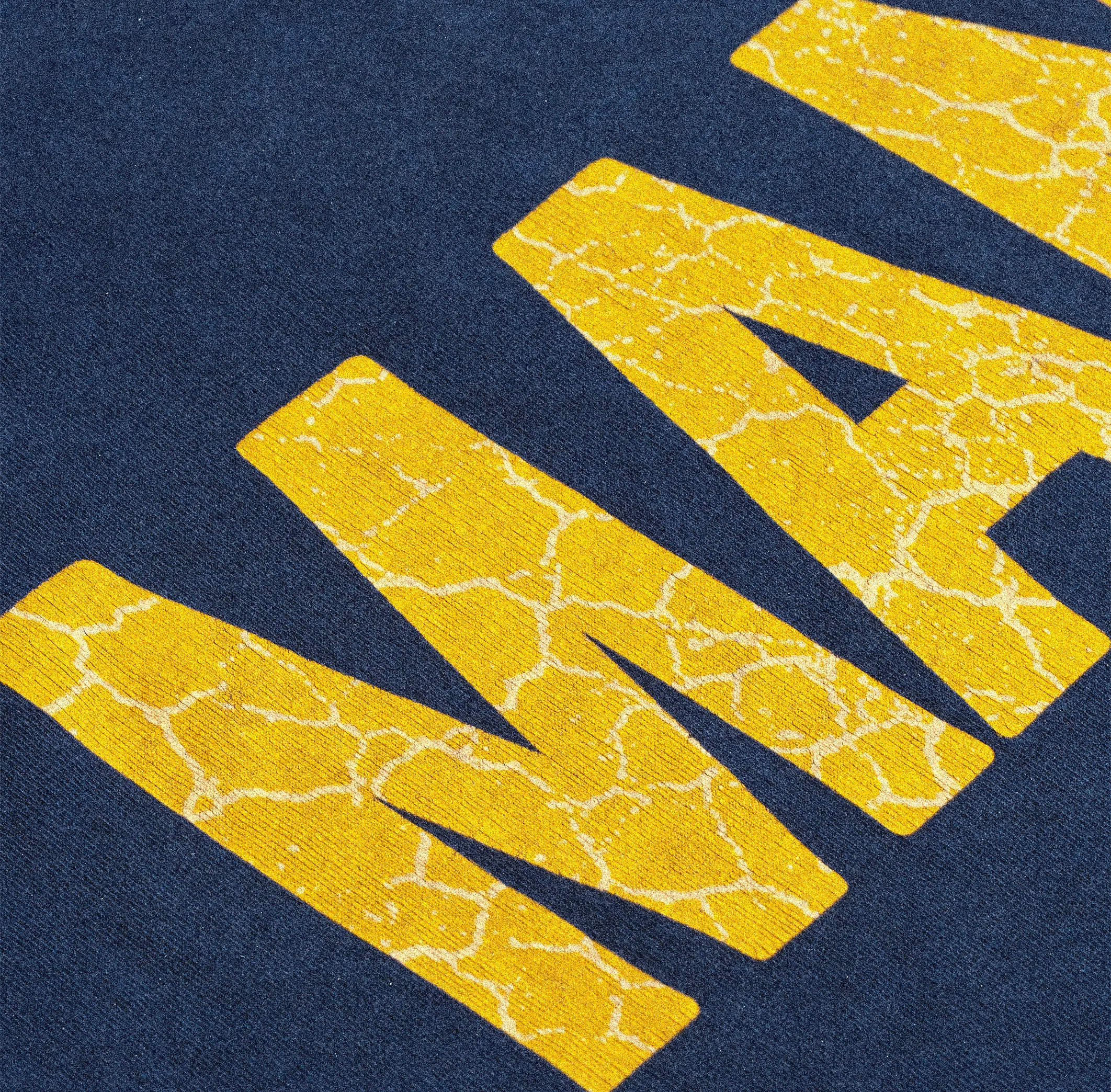 Zoom sur logo perlé Mania sur hoodie clair.